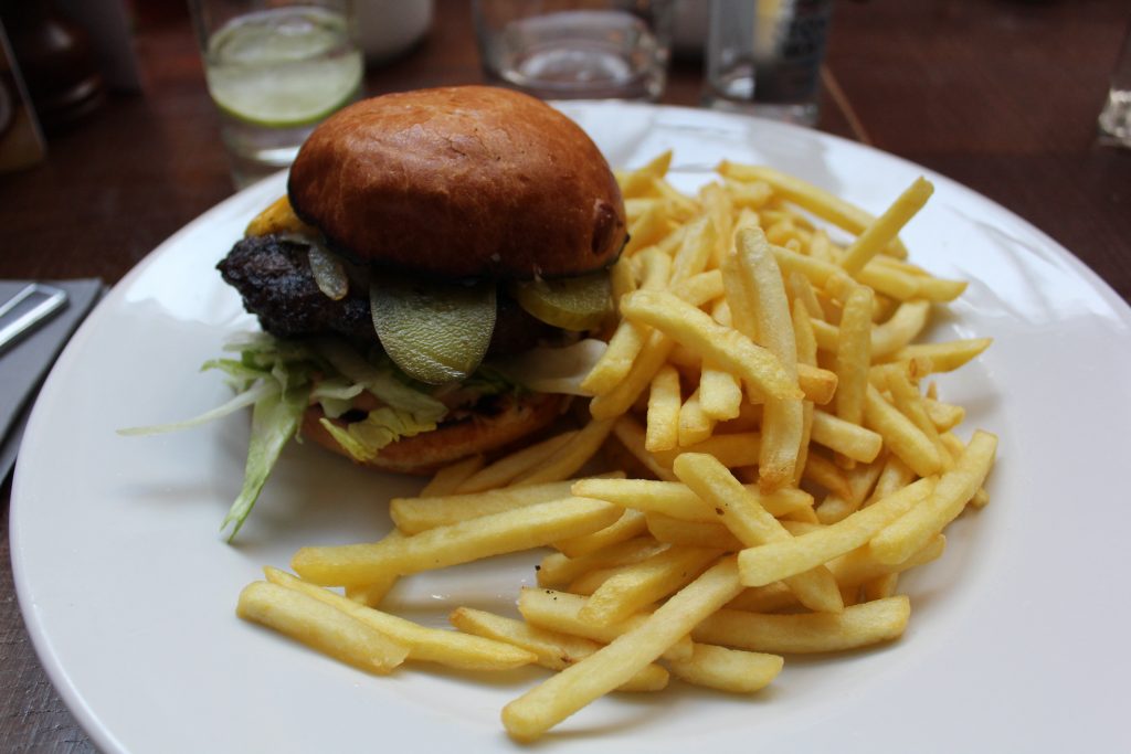 My main course of Prime British cheese burger, ale onions, gherkins, fries.